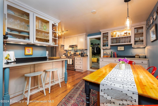 kitchen featuring a breakfast bar area, white cabinetry, and appliances with stainless steel finishes