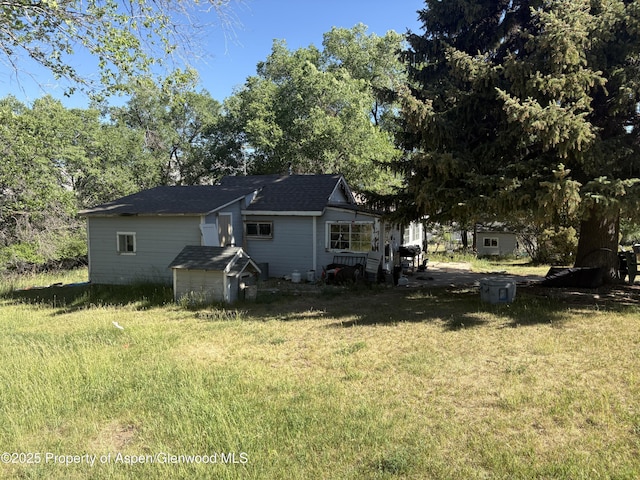 245 County Road 338, Parachute, CO 81635 - rear view of house with a storage unit and a lawn