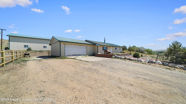 25 W 20th St, Craig, CO 81625 - view of front facade with dirt driveway, a garage, and a metal roof