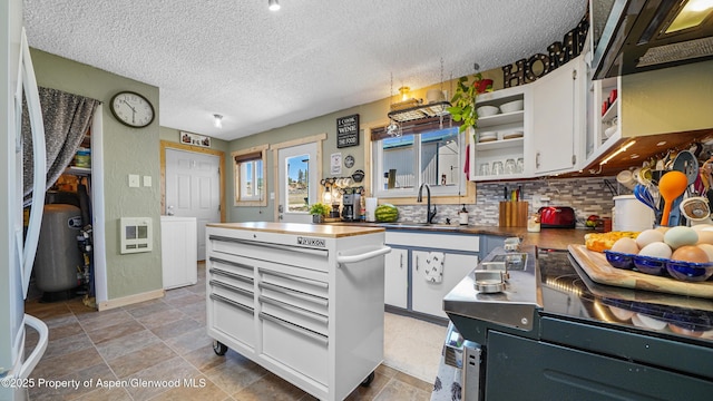 25 W 20th St, Craig, CO 81625 - kitchen featuring tasteful backsplash, a textured ceiling, white cabinets, heating unit, and a center island