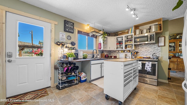 25 W 20th St, Craig, CO 81625 - kitchen featuring stainless steel appliances, open shelves, backsplash, white cabinets, and a kitchen island