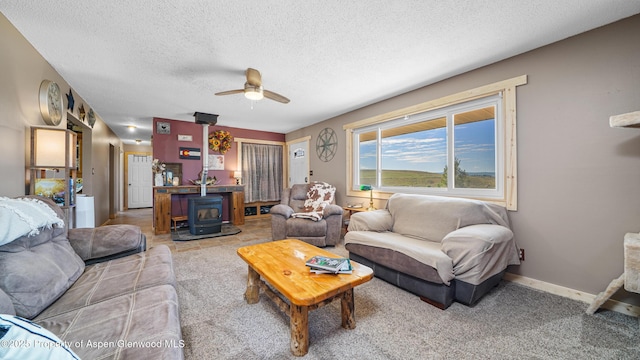 25 W 20th St, Craig, CO 81625 - living area featuring a wood stove, a ceiling fan, a textured ceiling, and light colored carpet