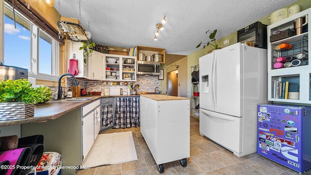 25 W 20th St, Craig, CO 81625 - kitchen featuring white fridge with ice dispenser, open shelves, stainless steel microwave, tasteful backsplash, and white cabinetry