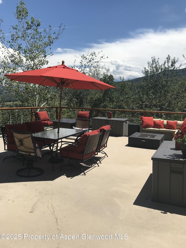 view of patio with an outdoor living space with a fire pit