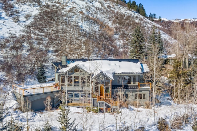 snow covered rear of property with a mountain view