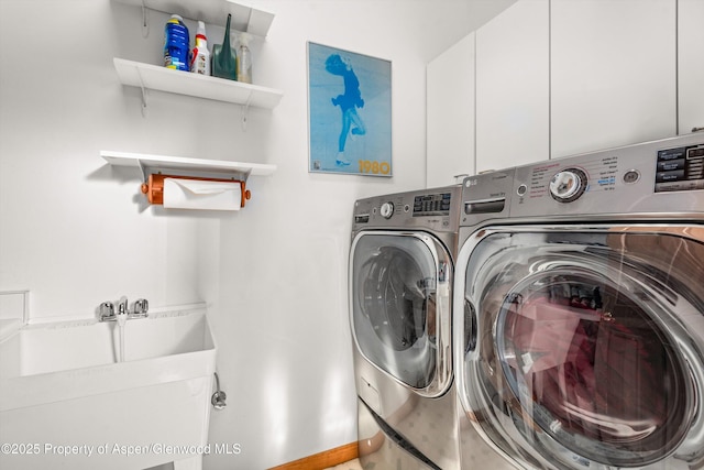 washroom featuring cabinets and washing machine and clothes dryer