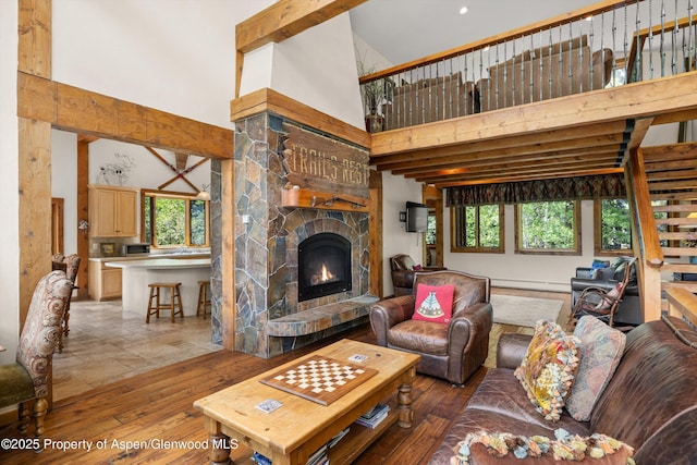 117 Deer Ln, Marble, CO 81623 - living area with a towering ceiling, healthy amount of natural light, a fireplace, light wood-style flooring, and baseboard heating