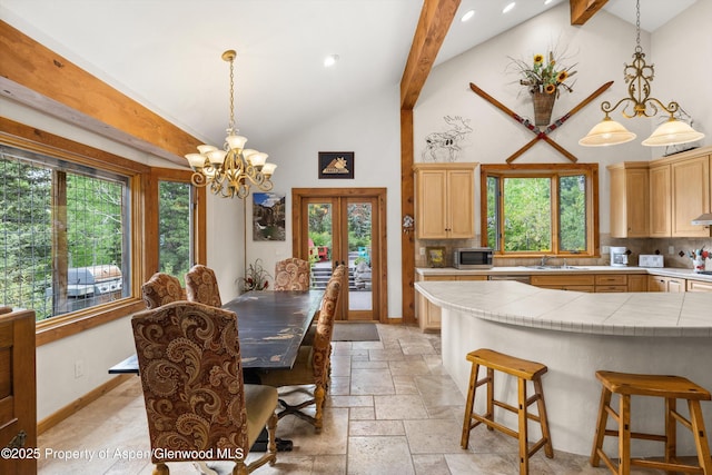 117 Deer Ln, Marble, CO 81623 - dining area featuring stone tile flooring, high vaulted ceiling, a chandelier, french doors, and plenty of natural light