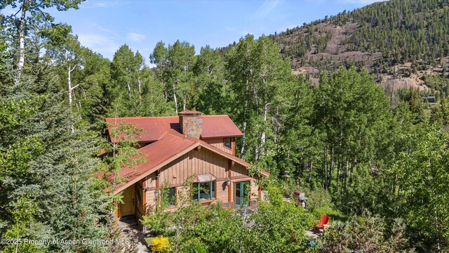 117 Deer Ln, Marble, CO 81623 - view of front of house with a forest view, a metal roof, and a chimney