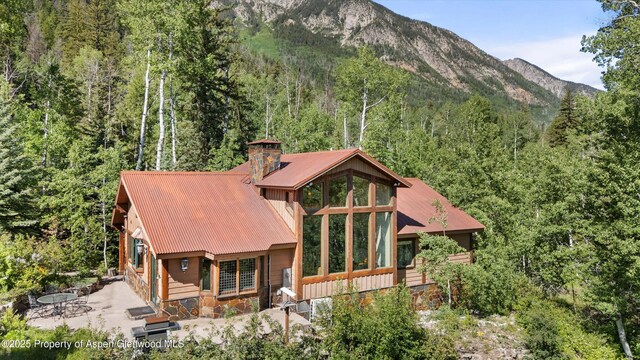 117 Deer Ln, Marble, CO 81623 - back of house featuring stone siding, a forest view, a mountain view, and a metal roof