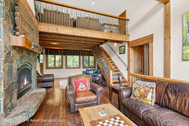 117 Deer Ln, Marble, CO 81623 - living room featuring a stone fireplace, hardwood / wood-style flooring, stairs, and a towering ceiling