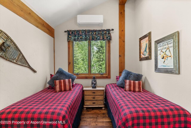 117 Deer Ln, Marble, CO 81623 - bedroom with a wall mounted air conditioner, wood finished floors, and lofted ceiling
