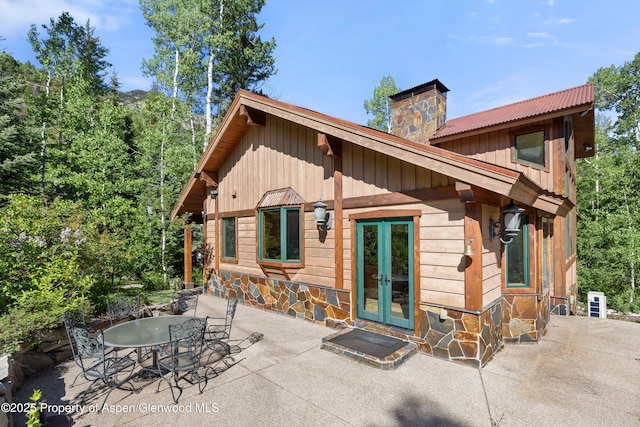 117 Deer Ln, Marble, CO 81623 - back of house with a chimney, a patio area, french doors, stone siding, and board and batten siding