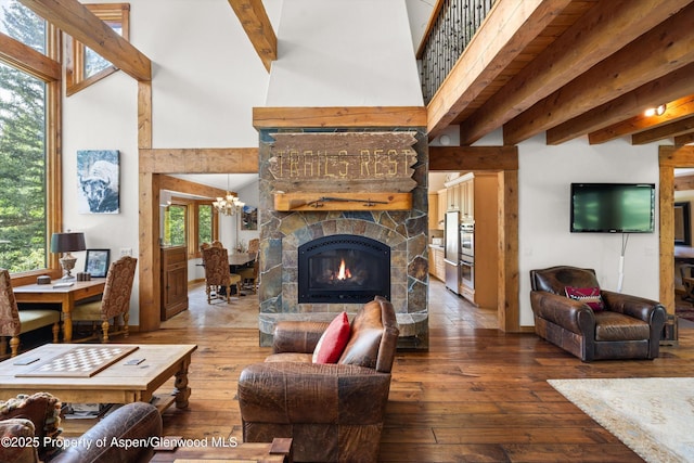 117 Deer Ln, Marble, CO 81623 - living area featuring wood-type flooring, beam ceiling, a high ceiling, a chandelier, and a stone fireplace