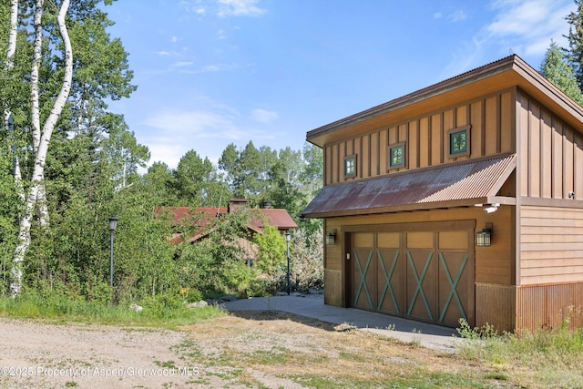 117 Deer Ln, Marble, CO 81623 - view of front of home with board and batten siding, a metal roof, and an attached garage