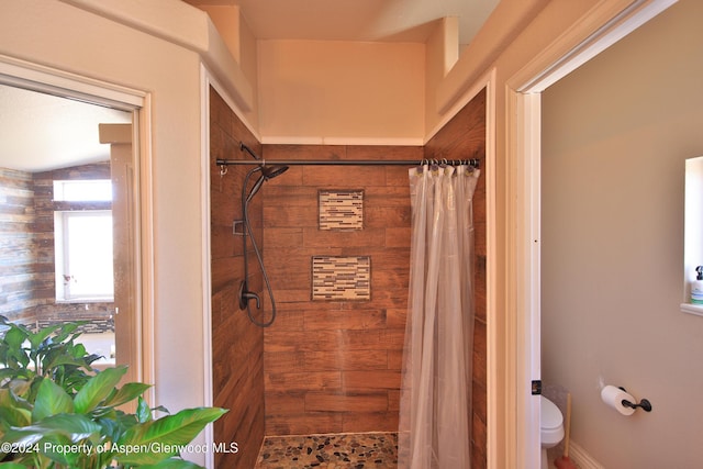 bathroom featuring a shower with curtain and toilet