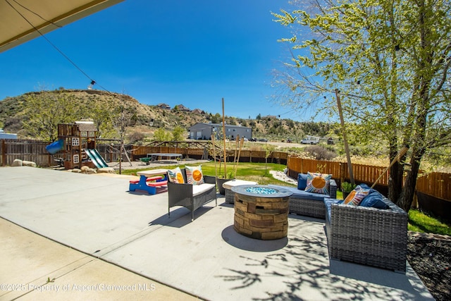 2086 Acacia Ave, Rifle, CO 81650 - fenced backyard featuring a playground, a mountain view, a patio area, and an outdoor living space with a fire pit