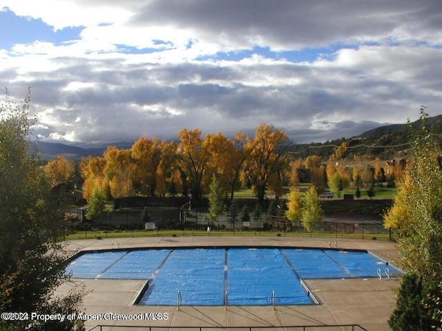 view of swimming pool with a mountain view