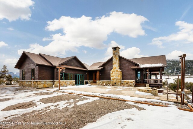 rustic home with stone siding and a chimney