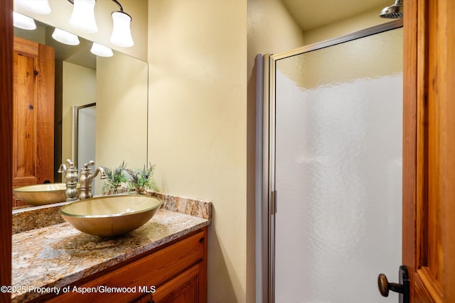 bathroom with vanity and a shower with door