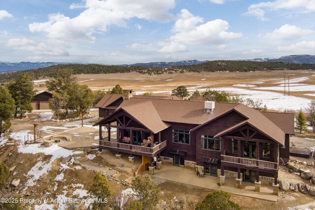 rear view of property with a balcony and a mountain view