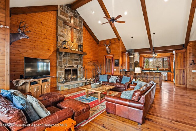 857 Indian Rock Rd, Silt, CO 81652 - living area featuring wood walls, high vaulted ceiling, beamed ceiling, hardwood / wood-style floors, and a ceiling fan