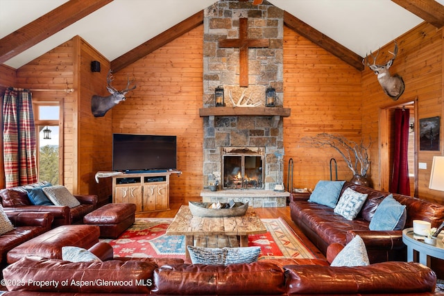 living room with beamed ceiling, a stone fireplace, hardwood / wood-style floors, and wood walls