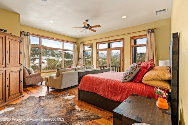 bedroom featuring ceiling fan, access to outside, light wood-type flooring, and french doors