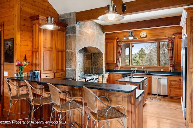 kitchen with stainless steel appliances, hanging light fixtures, a breakfast bar, and kitchen peninsula