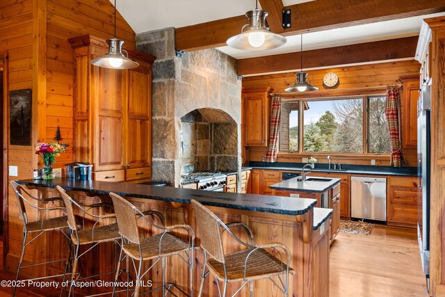 bar with light wood-style flooring, wooden walls, stainless steel dishwasher, and decorative light fixtures