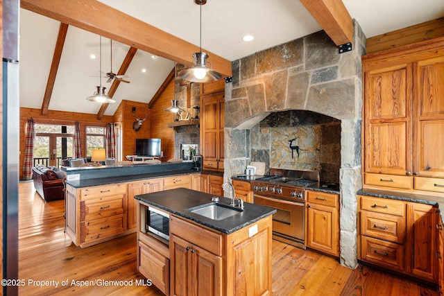 kitchen featuring pendant lighting, sink, vaulted ceiling with beams, stainless steel appliances, and light wood-type flooring