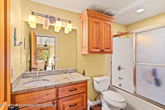 bathroom with toilet, combined bath / shower with glass door, and vanity