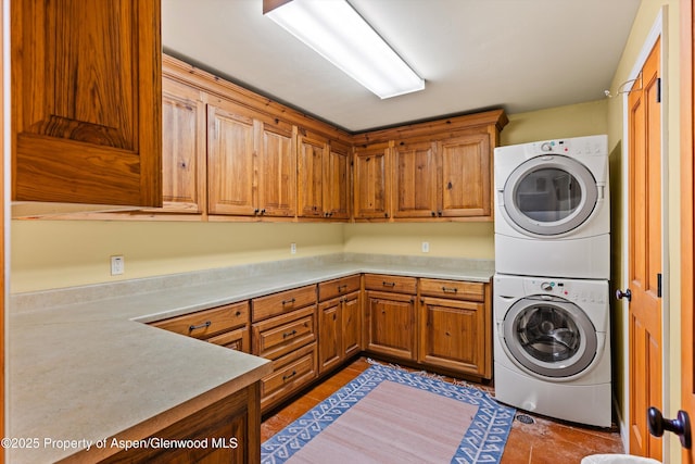 laundry room featuring cabinets and stacked washer and dryer