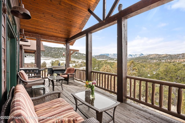 sunroom / solarium with wood ceiling, lofted ceiling, and a mountain view