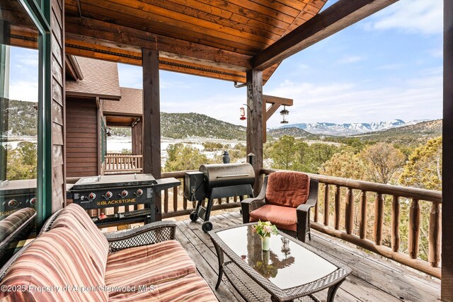 wooden terrace featuring a mountain view and area for grilling