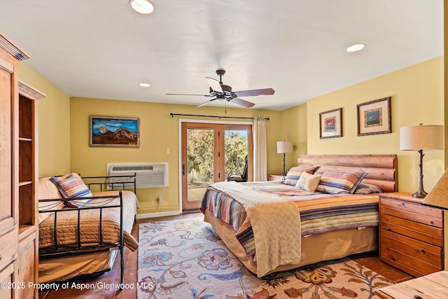 bedroom featuring ceiling fan, access to exterior, a wall mounted AC, and light hardwood / wood-style flooring