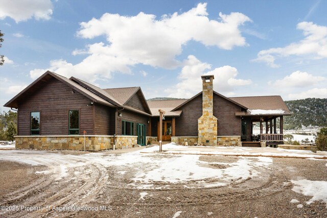 chalet / cabin featuring stone siding and a chimney