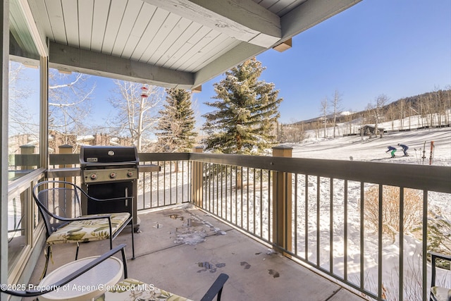 snow covered back of property featuring a grill