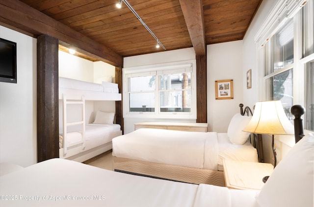 bedroom with beam ceiling, track lighting, and wooden ceiling