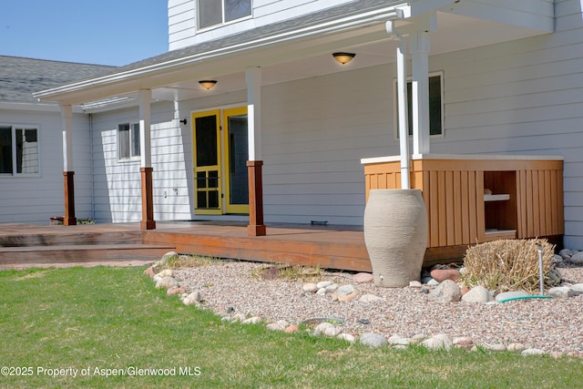 exterior space with a wooden deck and a shingled roof
