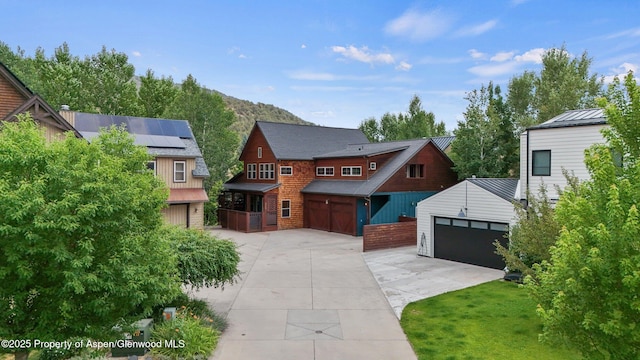225 Juniper Ct, Basalt, CO 81621 - view of front of property with a garage, an outbuilding, solar panels, concrete driveway, and brick siding