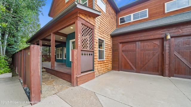 225 Juniper Ct, Basalt, CO 81621 - view of exterior entry featuring a garage, roof with shingles, and driveway