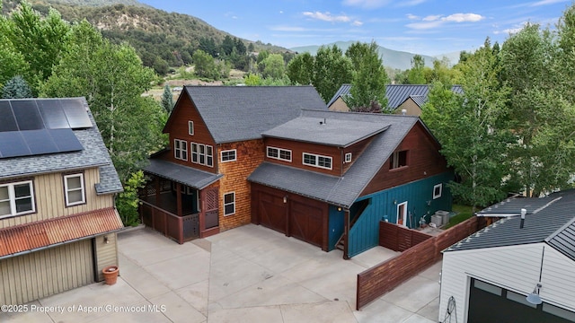225 Juniper Ct, Basalt, CO 81621 - rear view of house featuring roof with shingles, a mountain view, solar panels, an attached garage, and concrete driveway
