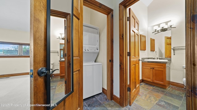 225 Juniper Ct, Basalt, CO 81621 - hallway featuring stacked washing machine and dryer and stone tile floors