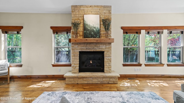 225 Juniper Ct, Basalt, CO 81621 - unfurnished living room with hardwood / wood-style floors, plenty of natural light, and a stone fireplace