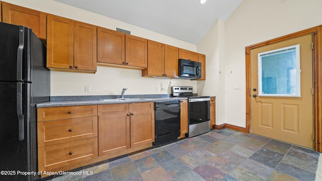 225 Juniper Ct, Basalt, CO 81621 - kitchen with black appliances, lofted ceiling, dark countertops, dark stone finish flooring, and brown cabinets