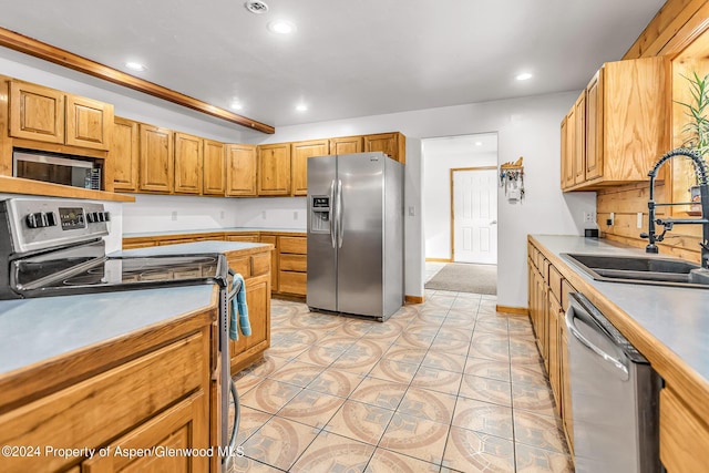 kitchen featuring light tile patterned flooring, sink, and appliances with stainless steel finishes