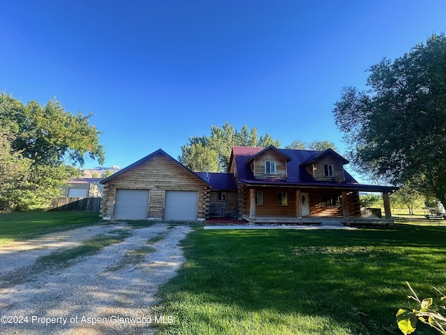 log home with covered porch, a garage, and a front yard