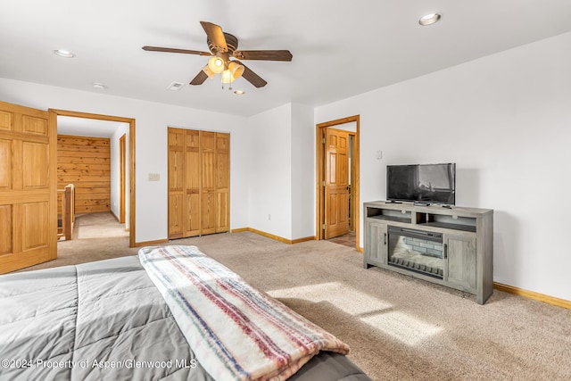 carpeted bedroom with ceiling fan and a closet