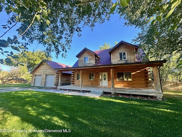 cabin featuring a porch, a garage, and a front lawn